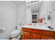Cozy bathroom with wood vanity, white sink, and white toilet at 11820 W 66Th Pl # C, Arvada, CO 80004