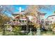 Exterior view of the back of the house showing a large deck, patio, and backyard with mature trees and landscaping at 10346 E Crestridge Ln, Englewood, CO 80111