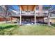 Exterior view of two decks on a brick home overlooking the manicured lawn, yard and garden at 10346 E Crestridge Ln, Englewood, CO 80111