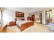 This bedroom provides a large bed, side tables and a view leading to the bathroom and staircase at 10346 E Crestridge Ln, Englewood, CO 80111