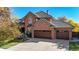 Charming brick home featuring an attached three-car garage and lush landscaping at 10346 E Crestridge Ln, Englewood, CO 80111