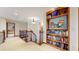 Upstairs hallway with staircase and built-in bookcase stocked with books and decorative items at 10346 E Crestridge Ln, Englewood, CO 80111