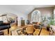 Charming living room with hardwood floors, a grand piano, comfortable sofa, and a large arched window at 10346 E Crestridge Ln, Englewood, CO 80111