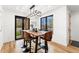 Modern dining area features a wood table, stylish chairs, modern light fixture, and large windows overlooking the outdoors at 1675 S Steele St, Denver, CO 80210