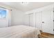 Bright bedroom featuring a large window, plush bedding, and ample closet space at 9093 Dudley St, Westminster, CO 80021