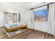 Well-lit bedroom with hardwood floors, large windows, and neutral decor at 9093 Dudley St, Westminster, CO 80021