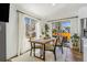 Bright dining area with a modern wooden table, natural lighting, and access to the backyard at 9093 Dudley St, Westminster, CO 80021