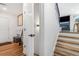 Hallway with hardwood floors leading to stairs and featuring white doors and neutral decor at 9093 Dudley St, Westminster, CO 80021