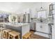 Modern kitchen with stainless steel appliances, white cabinets, and a large island with seating at 9093 Dudley St, Westminster, CO 80021