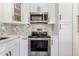 Updated kitchen with stainless steel appliances, white cabinetry, and elegant tile backsplash at 9093 Dudley St, Westminster, CO 80021