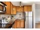 Functional kitchen includes wood cabinetry, granite countertops, and stainless steel refrigerator at 1419 Detroit St # 25, Denver, CO 80206