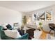 Bright living room features stylish decor, hardwood floors, and a large window for natural light at 1419 Detroit St # 25, Denver, CO 80206