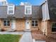 Exterior elevation view of townhome with brick facade, grey shingles, white trim, and a wreath on the door at 1517 S Owens St # 9, Denver, CO 80232