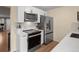 Bright kitchen featuring white cabinets, stainless steel appliances, and sleek countertops at 1517 S Owens St # 9, Denver, CO 80232
