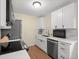 Well-lit kitchen featuring white cabinets, stainless steel appliances, and a modern backsplash at 1517 S Owens St # 9, Denver, CO 80232