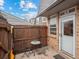 Patio area with weathered wood fence, small table with two chairs, and the front door entrance to unit #9 at 1517 S Owens St # 9, Denver, CO 80232
