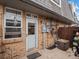 Brick patio with the front door to unit #9 plus a pair of bikes and A/C unit mounted to the wall at 1517 S Owens St # 9, Denver, CO 80232