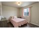 Charming bedroom with pink accents, natural light from window, and wood-look flooring at 6889 E 119Th Ave, Thornton, CO 80233