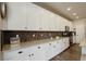 A stunning kitchen features granite countertops, tiled backsplash and white cabinetry at 6889 E 119Th Ave, Thornton, CO 80233