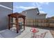 Outdoor BBQ grill under a wooden pergola with a red metal side table and chairs at 6889 E 119Th Ave, Thornton, CO 80233