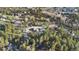 Expansive aerial view of a neighborhood nestled among lush trees, showcasing the area's natural beauty and community layout at 93 Greeley Blvd, Palmer Lake, CO 80133