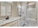 Bathroom featuring double sinks with granite countertops, white cabinetry, and a tiled shower/tub combo at 93 Greeley Blvd, Palmer Lake, CO 80133