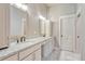 Bathroom featuring double sinks with granite countertops, white cabinetry, and a modern design at 93 Greeley Blvd, Palmer Lake, CO 80133