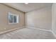 Bedroom features a bright window with natural light, neutral walls, and gray carpeting at 93 Greeley Blvd, Palmer Lake, CO 80133