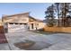Inviting home with a modern design, showcasing a spacious driveway, manicured lawn, and a welcoming front entrance at 93 Greeley Blvd, Palmer Lake, CO 80133