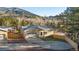 Attractive home with a well-manicured lawn, concrete driveway, a two-car garage, and scenic neighborhood views at 93 Greeley Blvd, Palmer Lake, CO 80133