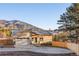 Charming single-Gathering home with a two-car garage and inviting blue front door, surrounded by lush greenery and mountain views at 93 Greeley Blvd, Palmer Lake, CO 80133