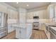 Spacious kitchen featuring white cabinets, stainless steel appliances, granite countertops, and a kitchen island at 93 Greeley Blvd, Palmer Lake, CO 80133