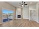 Spacious living room featuring access to the balcony, corner fireplace, and wood-look flooring at 93 Greeley Blvd, Palmer Lake, CO 80133