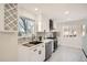 Modern kitchen featuring white shaker cabinets, quartz countertops, and stainless steel appliances at 71 W Fremont Ave, Littleton, CO 80120