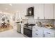 Modern kitchen with white cabinets, quartz countertops and a black range hood at 71 W Fremont Ave, Littleton, CO 80120