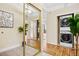 Hallway with tile and hardwood floors, mirrored closet door, laundry closet, and art at 7865 E Mississippi Ave # 105, Denver, CO 80247