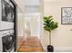 Hallway featuring a washer/dryer, closet, fiddle leaf fig plant and artwork at 7865 E Mississippi Ave # 105, Denver, CO 80247