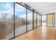 Enclosed sunroom featuring walls of windows overlooking the exterior and hardwood floors at 7865 E Mississippi Ave # 105, Denver, CO 80247