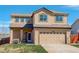 Two-story home with beige exterior, attached two-car garage, and manicured front lawn under clear blue skies at 11020 Glacier Park Cir, Parker, CO 80138