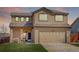 Two-story stucco home with a brown roof, attached garage, and green lawn at 11020 Glacier Park Cir, Parker, CO 80138