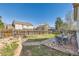 Large backyard with a stone patio, grassy area, wooden fence, and established trees at 13960 Grape St, Thornton, CO 80602