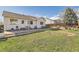 Well-maintained backyard with stone patio, grassy area, and view of the home's exterior at 13960 Grape St, Thornton, CO 80602