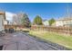 Spacious fenced backyard with a stone patio, landscaping, and grassy areas at 13960 Grape St, Thornton, CO 80602