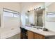 Bright bathroom featuring vanity with makeup seating, soaking tub, and ample natural light at 13960 Grape St, Thornton, CO 80602