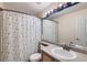 Cozy bathroom with black and white shower curtain and a sink in a wood cabinet at 13960 Grape St, Thornton, CO 80602