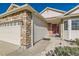 Inviting home exterior featuring stone accents, a red front door, and a manicured entrance at 13960 Grape St, Thornton, CO 80602