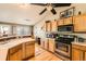Well-lit kitchen with oak cabinets, stainless steel appliances, and a breakfast bar at 13960 Grape St, Thornton, CO 80602