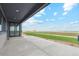 Spacious back patio featuring an overhang with views of expansive green fields and a blue sky at 2990 S Juliet Ct, Strasburg, CO 80136