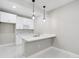 Basement kitchenette boasts modern pendant lights, white cabinets and sleek countertop at 2990 S Juliet Ct, Strasburg, CO 80136
