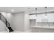 Finished basement with a kitchenette, recessed lighting and black railing on stairs at 2990 S Juliet Ct, Strasburg, CO 80136